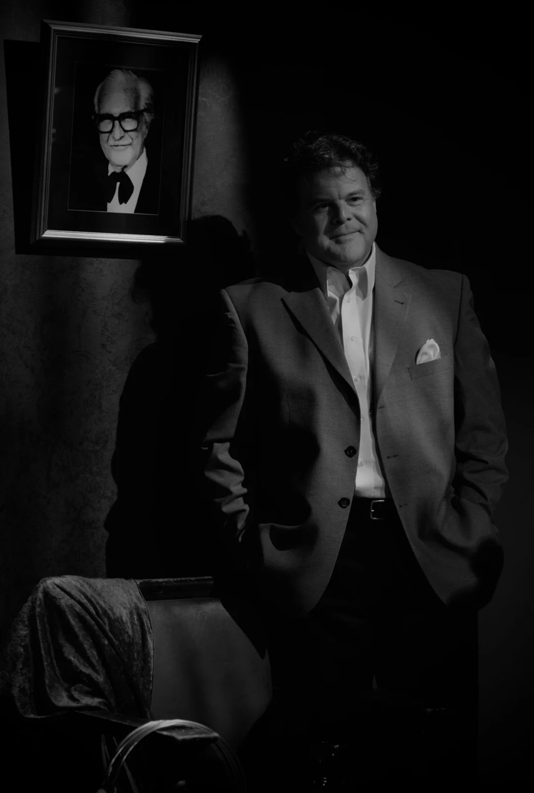 John beside a framed portrait of Dai Vernon
