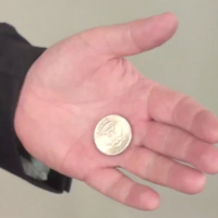 A coin resting in John's open palm